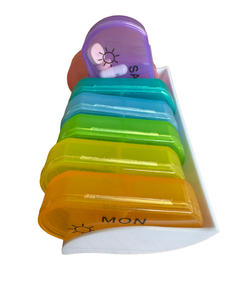 A coloutful pill sorter with removeable compartments. One end of one compartment is raised.